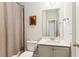 Well-lit bathroom includes a toilet, vanity, shower with curtain, decorative artwork, and a large mirror at 4972 Park Vale Dr, Sugar Hill, GA 30518