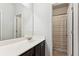 Neutral bathroom featuring a large mirror, single vanity, and shower with a striped curtain at 4972 Park Vale Dr, Sugar Hill, GA 30518