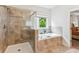 Bathroom featuring a shower and tub with tile surround and window at 4972 Park Vale Dr, Sugar Hill, GA 30518