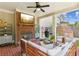 Cozy covered patio with brick fireplace, comfortable seating, ceiling fan, and outdoor grill at 4972 Park Vale Dr, Sugar Hill, GA 30518