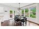Dining area with dark wood table, black chairs, and pendant lighting overlooking the backyard at 4972 Park Vale Dr, Sugar Hill, GA 30518