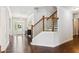 Bright foyer featuring hardwood floors, a staircase with dark wood railings, and a modern chandelier at 4972 Park Vale Dr, Sugar Hill, GA 30518