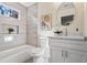 Modern bathroom featuring elegant tile work, a sleek vanity, and a stylish round mirror at 1270 Graymont Sw Dr, Atlanta, GA 30310