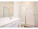 A well-lit bathroom featuring white cabinets, a sink, toilet, and a glass-enclosed shower at 1648 Florence Nw Run, Atlanta, GA 30318