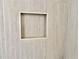 Close up of a tiled shower niche with modern wood-look walls at 1937 Don Juan Ln, Decatur, GA 30032