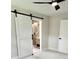 Bright bedroom with white walls, plush carpet, and a modern white barn door leading to a bathroom at 1937 Don Juan Ln, Decatur, GA 30032