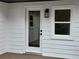 White home exterior featuring new siding, windows, and a glass panel entry door at 1937 Don Juan Ln, Decatur, GA 30032