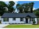 Charming one-story home with a freshly painted white brick exterior, dark shutters, and a well-manicured front yard at 1937 Don Juan Ln, Decatur, GA 30032