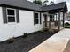 Renovated house boasting a white brick exterior, black shutters, and newly installed black mulch at 1937 Don Juan Ln, Decatur, GA 30032