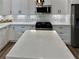 Close-up of kitchen island with a marble countertop, modern lighting, and stainless appliances at 1937 Don Juan Ln, Decatur, GA 30032