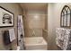 Clean bathroom featuring a shower-tub, tiled walls, and decorative framed prints and an arched mirror at 400 W Peachtree Nw St # 3216, Atlanta, GA 30308