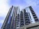 A view of the high-rise apartment building against a blue sky and white clouds at 400 W Peachtree Nw St # 3216, Atlanta, GA 30308