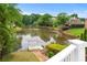 Lush backyard with a tranquil lake view, dock, and gazebo, surrounded by mature trees at 5070 Riverlake Dr, Peachtree Corners, GA 30097