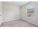 A clean bedroom with gray carpet, neutral walls, and a window that offers natural light at 1528 Wembley Dr, Douglasville, GA 30134