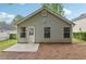 Rear exterior showcasing vinyl siding, windows, a door, and a concrete patio at 1528 Wembley Dr, Douglasville, GA 30134