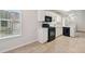 A bright kitchen with white cabinets and modern, black appliances, including a gas range at 1528 Wembley Dr, Douglasville, GA 30134