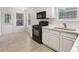 Bright kitchen with white cabinets, modern appliances, and tile flooring; great natural light at 1528 Wembley Dr, Douglasville, GA 30134