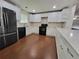 Spacious kitchen with white cabinets, black appliances, and hardwood floors at 2913 Jordan Forest Trl, Lawrenceville, GA 30044