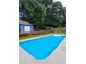 Backyard pool with adjacent pool house, surrounded by lush greenery and mature trees for added privacy at 2913 Jordan Forest Trl, Lawrenceville, GA 30044