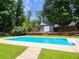 Enjoy outdoor bliss with this refreshing pool and charming blue storage shed in a lush backyard setting at 2913 Jordan Forest Trl, Lawrenceville, GA 30044