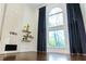 Bright living room with tall arched windows, dark wood floors, fireplace, and floating shelves at 3258 Bransley Way, Duluth, GA 30097