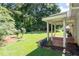 Charming backyard with a covered brick patio and lush green lawn surrounded by trees at 334 Bridgewood Se Dr, Conyers, GA 30094