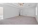 Spacious bedroom featuring neutral carpet, tray ceiling with fan, and bright natural light at 334 Bridgewood Se Dr, Conyers, GA 30094