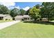 Charming single-story home with a well-manicured lawn, mature trees, and an attached two-car garage at 334 Bridgewood Se Dr, Conyers, GA 30094