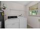 Functional laundry area with washer, dryer, and shelving for storage at 334 Bridgewood Se Dr, Conyers, GA 30094