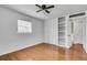 Bright bedroom with hardwood floors, a ceiling fan, built-in shelving and a closet for ample storage at 5440 Huron Dr, Lake City, GA 30260