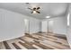 This bedroom features wood paneled walls, ceiling fan, and stylish hardwood floors at 5440 Huron Dr, Lake City, GA 30260