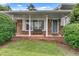 Charming front porch with brick accents, white pillars, and a cozy bench at 5440 Huron Dr, Lake City, GA 30260