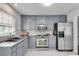 Updated kitchen with marble countertops, gray cabinets, and stainless steel appliances at 5440 Huron Dr, Lake City, GA 30260