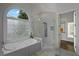 Bathroom includes a soaking tub under an arched window, next to a walk-in shower with white tile at 8630 Moor Park Run, Duluth, GA 30097