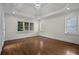 Bedroom featuring hardwood floors, tray ceiling with decorative lights, and windows with shutters at 8630 Moor Park Run, Duluth, GA 30097