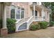 Brick home showcasing a charming entry with an elegant staircase and manicured bushes at 8630 Moor Park Run, Duluth, GA 30097