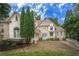 Elegant two-story brick home boasts a landscaped front yard, multiple garage spaces, and an inviting entrance at 8630 Moor Park Run, Duluth, GA 30097