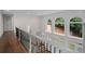 Hallway with staircase with black iron railing and arched transom windows at 8630 Moor Park Run, Duluth, GA 30097