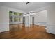 Open-concept living room featuring hardwood floors, modern lighting, and large windows with backyard views at 8630 Moor Park Run, Duluth, GA 30097