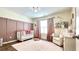 Bright Bedroom with pink accent wall and curtains, wood floors, and overhead lighting at 109 Red Fox Dr, Dallas, GA 30157