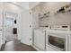 Convenient laundry room area with white front-load washer and dryer, shelving, and hardwood-style floors at 3440 Hardy St, Duluth, GA 30096