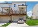 Rear exterior view of townhomes with private decks, ground level garages, and a well-maintained lawn at 3440 Hardy St, Duluth, GA 30096