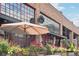 Inviting outdoor patio with flowers and umbrellas at a restaurant with a large windowed facade at 3440 Hardy St, Duluth, GA 30096