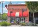 Charming brick chocolatier storefront with a red awning, street sign, and inviting curb appeal at 3440 Hardy St, Duluth, GA 30096