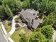 Aerial view of a luxury home featuring lush landscaping, a winding driveway, and a large private lot at 4634 Whitestone Way, Suwanee, GA 30024