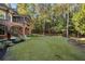 Spacious backyard featuring a well-maintained lawn and partial view of the brick exterior of the home at 4634 Whitestone Way, Suwanee, GA 30024