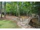 Charming wooden bridge over a tranquil stream in a lush, wooded backyard setting at 4634 Whitestone Way, Suwanee, GA 30024