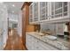 Butler's pantry featuring custom cabinetry, granite countertops, and mirrored backsplash at 4634 Whitestone Way, Suwanee, GA 30024