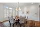 Formal dining room featuring a large round table, chandelier, and natural light from large windows at 4634 Whitestone Way, Suwanee, GA 30024