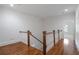 Upstairs hallway with hardwood floors, white trim, and natural light streaming through the window at 4634 Whitestone Way, Suwanee, GA 30024